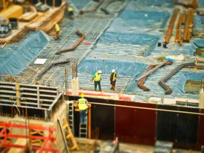 Aerial view of a large construction site with two workers in view
