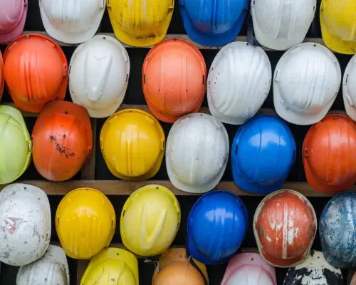 A wall of rainbow hard hats