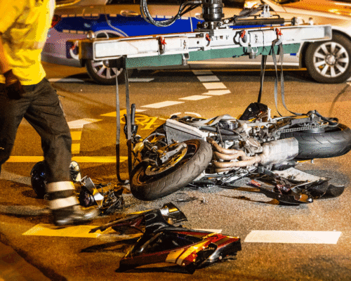 A mangled motorcycle laying on the street after a crash.