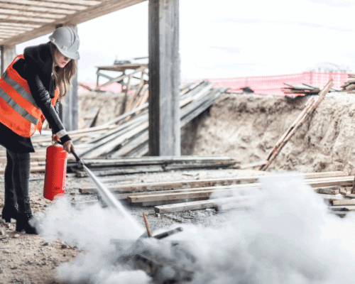 A construction worker putting out a fire at a construction site.