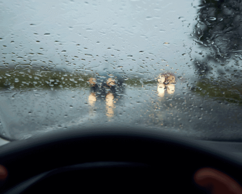 A blurry windshield with raindrops on it.
