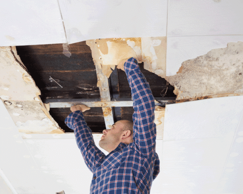 A man patching a hole in a ceiling