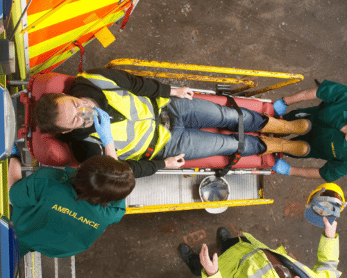 Construction workers in hard hats coordinating tasks on a busy building site viewed from above, surrounded by scaffolding, rebar, and tools
