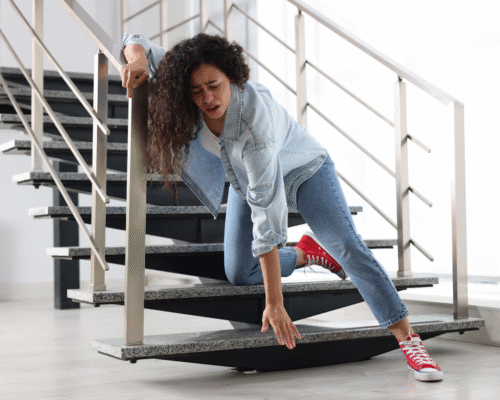 A woman falling or having tripped on a modern interior staircase, illustrating an incident that requires surveillance footage trip and fall NYC to prove fault.