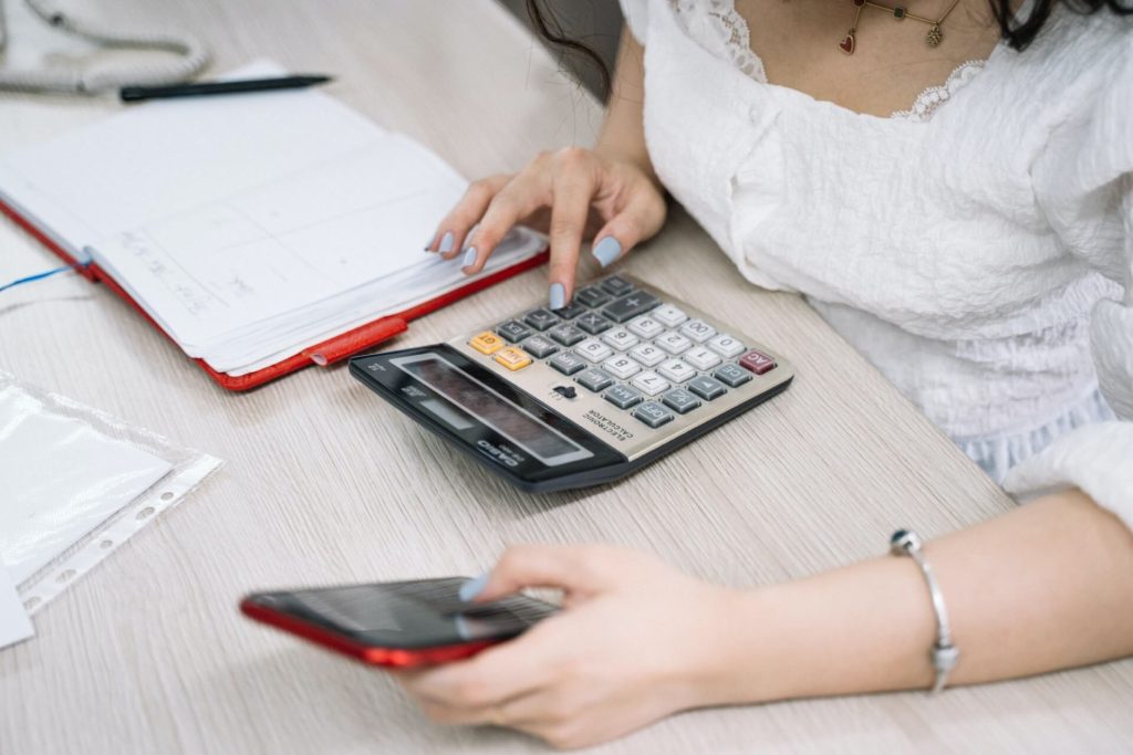 Woman doing math on calculator and phone